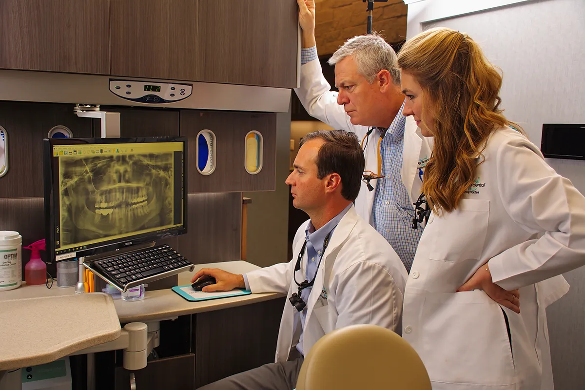 The DeKoch dentists reviewing a patient's treatment plan at the office